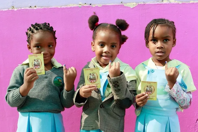 Girls in Mozambique show off their Shot@Life immunization cards for World Immunization Week