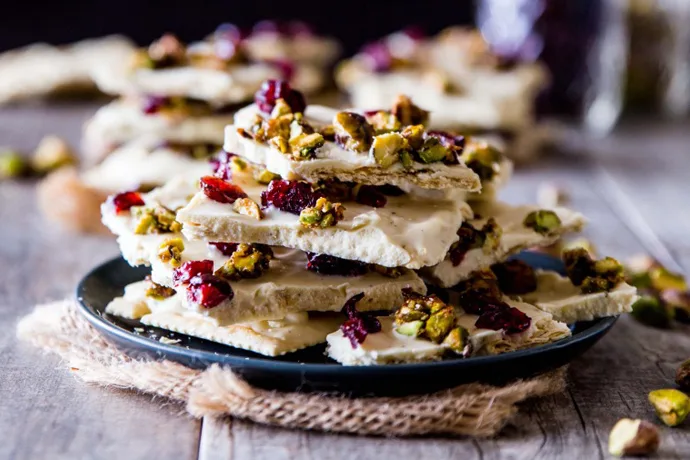 Holiday chocolate bark recipes: White Chocolate Saltine Bark with Candied Pistachios and Cranberries