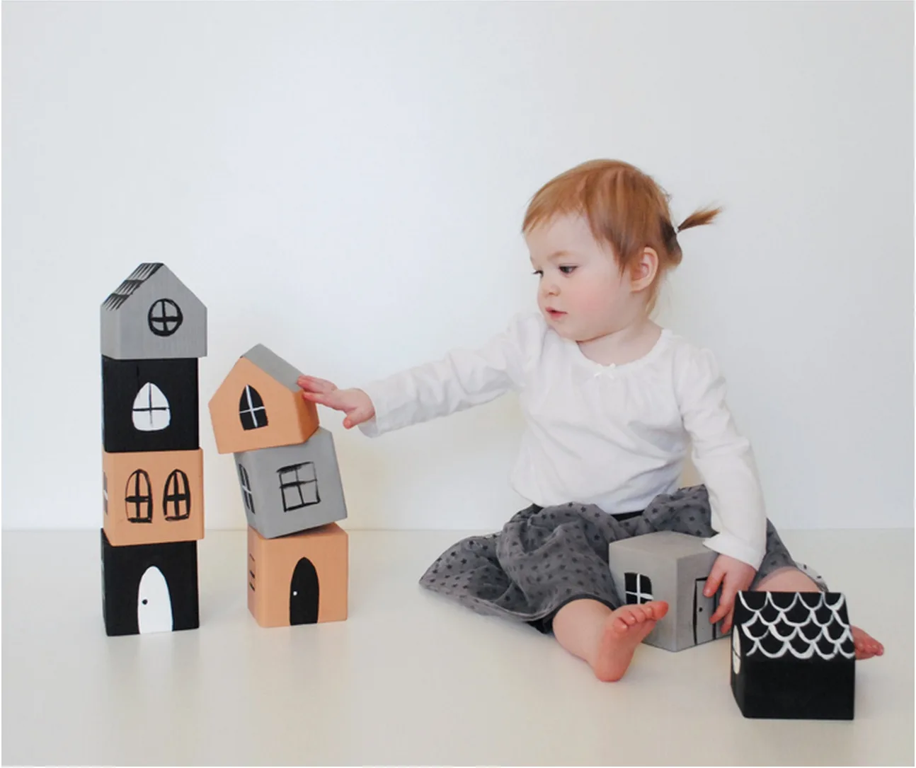 Ways to make old wooden blocks new again, like this painted house craft from Mer Mag