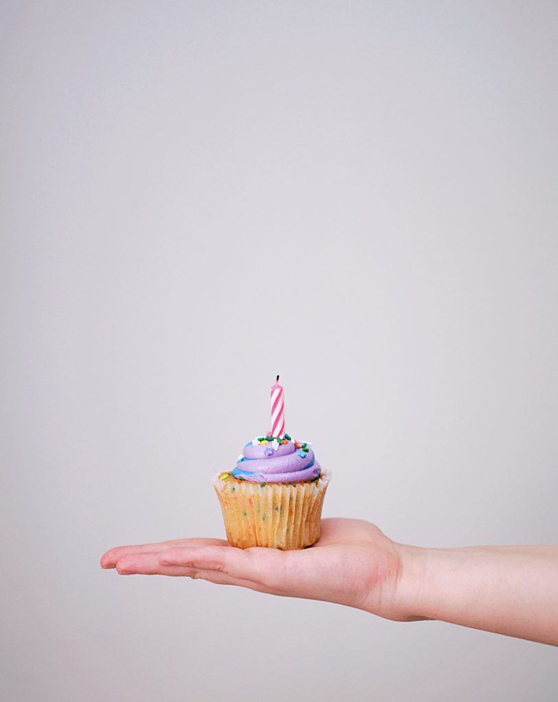 Individual cupcake with birthday candle for safe celebrating during Covid-19 pandemic