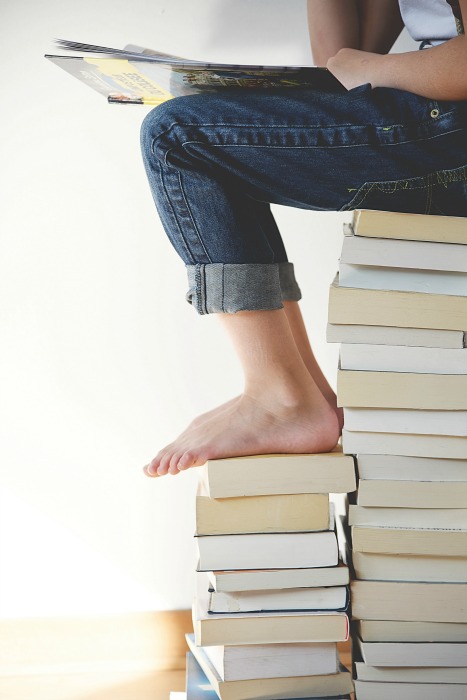 Kid Reading On A Stack Of Books